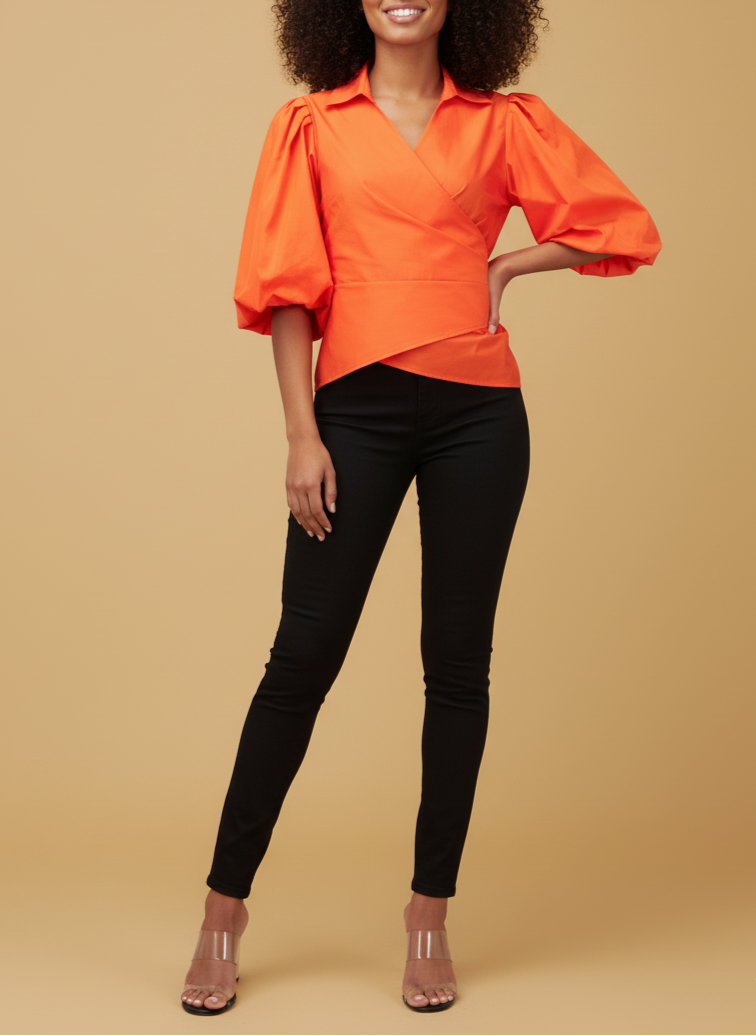 Woman wearing an orange blouse with puff sleeves and black pants on a beige background