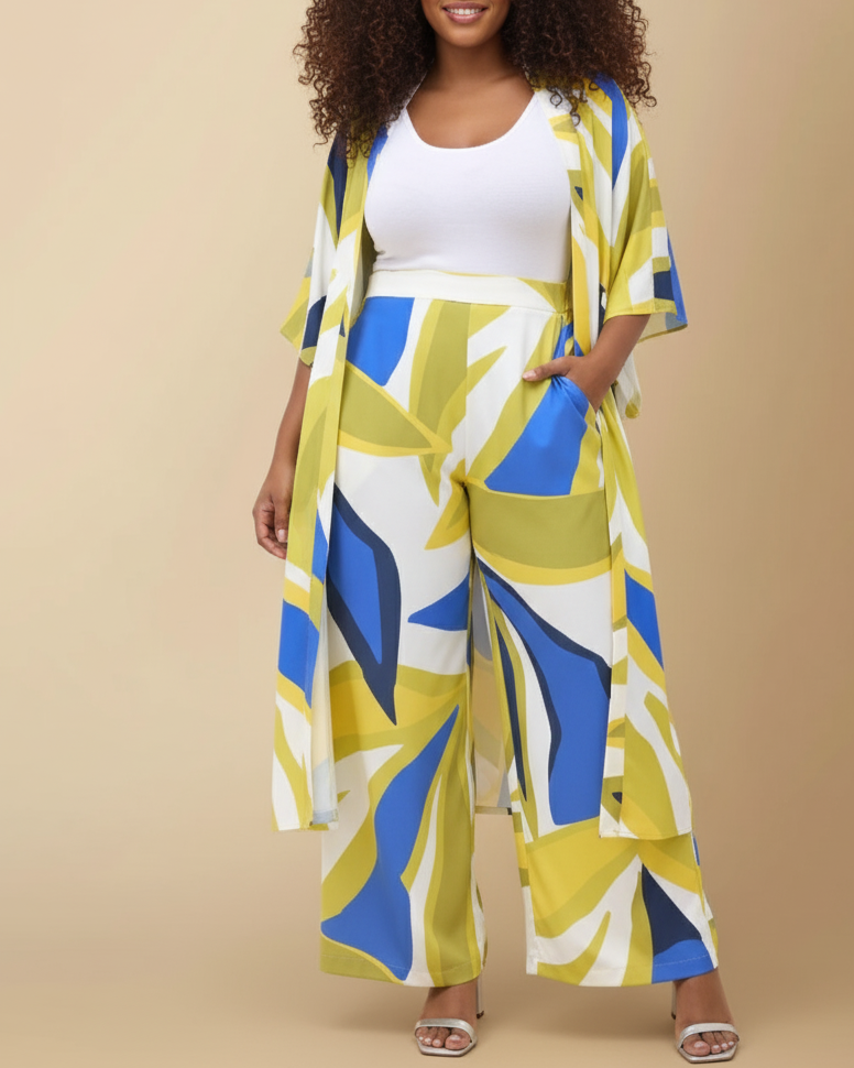 Front shot of a model wearing blue and green leaf-patterned kimono and pants with a white top against a beige background