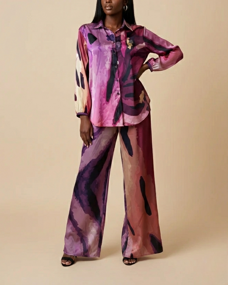 Front shot of a model wearing a colorful , Peruvian Lily floral printed button down shirt and wide leg pants set on a beige background.